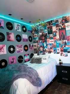 a bedroom with record records on the wall and lights above it, along with a bed