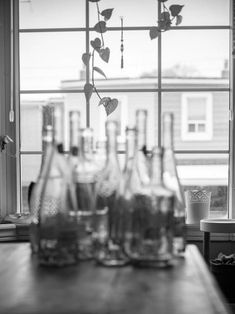 several empty bottles on a table in front of a window