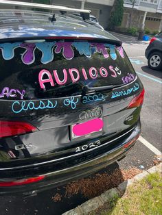 a car that has some writing on the side of it and is parked in a parking lot