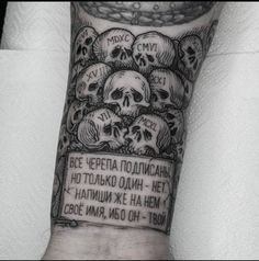 a man's arm with skulls on it and an inscription in russian above the skull