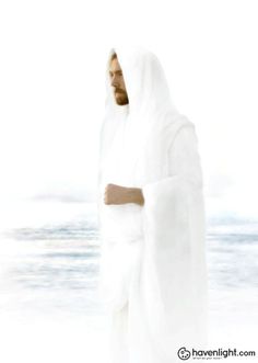 a man in white robes standing on the beach