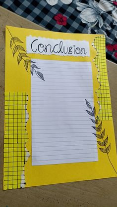 a yellow piece of paper with the word conclusion written on it next to some flowers