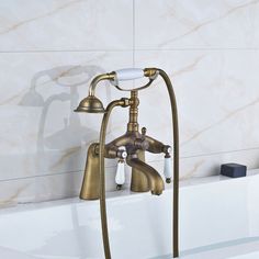 the faucet in the bathtub is gold and has two handles on each side