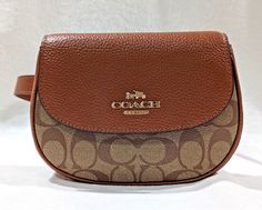 This Coach belt bag, made of signature coated canvas and leather, is a stylish and practical accessory for any occasion. The khaki and redwood exterior color, along with the gold-plated hardware and logo print accents, give it a designer look. The bag's dimensions are 5.5 inches in width, 7.5 inches in height, and 2 inches in depth, making it a mini-sized bag with enough space to carry your essentials. The bag has a cross-body strap, adjustable chain strap, and inner pockets to suit your needs. The bag's closure is a snap, giving you easy access to your belongings. This Coach Saddle Belt Bag is perfect for travel, casual outings, and workwear. It has a vintage look but is a new item.  Orig price $ 298 Detail: Signature coated canvas, leather Inside multifunction pocket Snap closure, fabric Coach Belt Bag, Oversized Handbags, Chloe Bags Handbags, Navy Bag, Coach Belt, Leather Belt Bag, Coach Leather, Canvas Leather, Chain Strap