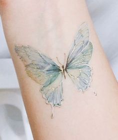 a white butterfly tattoo on the arm