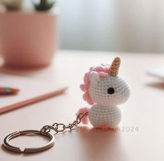 a crocheted unicorn keychain sitting on top of a table