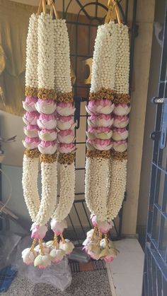 two rows of macaroni hanging from hooks in front of a door with other macaroni's attached to it