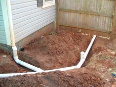 a pipe is in the ground next to a house