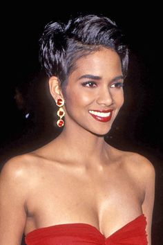 a woman in a red dress smiling at the camera