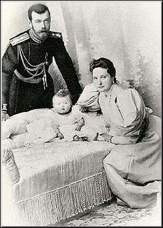 an old black and white photo of a man in uniform standing next to a woman holding a baby