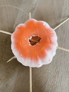 an orange cake sitting on top of a wooden stick