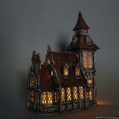 a lighted model of a gothic - style house with windows and lights on the roof