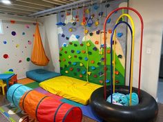 children's playroom with climbing walls and toys on the floor, including an inflatable tire