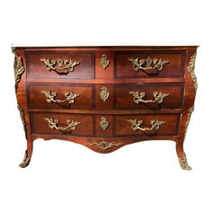 an antique chest of drawers with gold leaf decoration on the top and bottom drawer doors