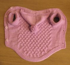 a pink knitted sweater with two holes in the middle