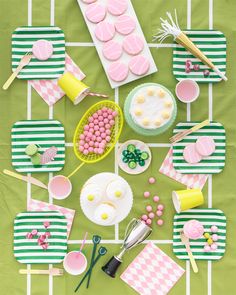 a table topped with lots of pink and green desserts next to cupcakes