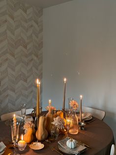 a dining room table with candles and dishes on it