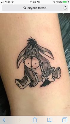 a small tattoo on the leg of a person with a rabbit sitting next to it