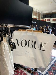 there is a sign that says voque in front of some clothes on display at the store