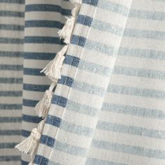 blue and white striped curtains with tassels hanging from the side, closeup