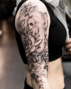 an elephant and roses tattoo on the right arm is shown in black and grey colors