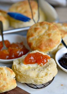 biscuits with jam and jelly on them sitting on a table