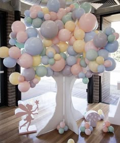 a balloon tree in the middle of a room with lots of balloons on top of it