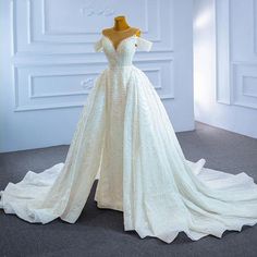 a white wedding dress on display in a room