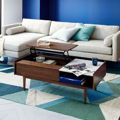 a living room with blue walls and white furniture in the center, including a coffee table