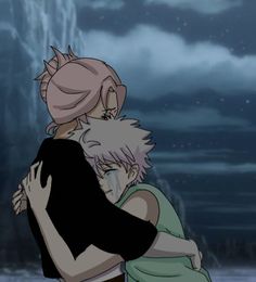 two people hugging each other in front of a dark sky with clouds and water behind them