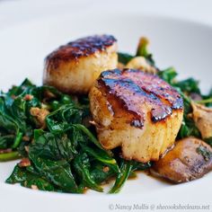 seared scallops and greens on a white plate