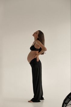 a pregnant woman standing in front of a camera