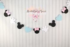 mickey and minnie mouse party decorations on a striped wall with pink, blue, and white paper bunting