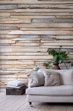 a white couch sitting next to a wall with wooden planks on it's side