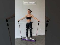 a woman standing on top of a pair of skis in front of a white wall