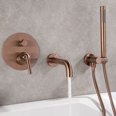 two faucets are connected to the side of a bathtub with water running from it