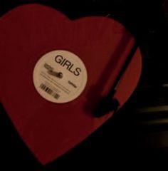 a red heart with the word girls on it and a barcode sticker attached to it