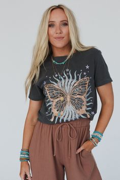 Embrace your boho style with the Butterfly Sun Graphic Tee, soon to be your go - to graphic tee and closet essential! Comfortable, Cotton tee shirt fabric Relaxed and slouchy silhouette for ultimate comfort Classic crew neckline with loose short sleeves So cute butterfly and sun with stars center graphic Pair with: Headstart Waffle Knit Seamless Brami, Lets Jet Set Wide Leg Pants and Seeing Stars Bracelet Set. *Due to lighting and differences in monitors, actual colors may vary slightly from wha Festival Graphic Print Relaxed Fit T-shirt, Relaxed Fit Crew Neck T-shirt For Festivals, Bohemian Short Sleeve T-shirt, Spring Festival Casual T-shirt, Bohemian Short Sleeve Beach T-shirt, Bohemian Crew Neck T-shirt For Summer, Bohemian Summer Loungewear Tops, Casual Screen Print T-shirt For Festival, Bohemian Graphic Print Tops For Vacation