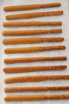 six wooden sticks are lined up on a piece of paper with glittery gold flecks