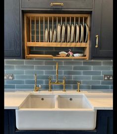 a kitchen with blue cabinets and white counter tops, two double - basin sinks in the center