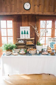 a table with food and plants on it in the middle of a wooden floored room