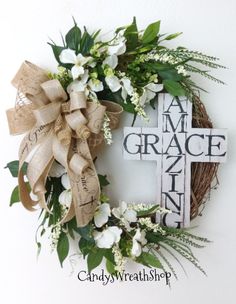 a wreath with flowers and a cross hanging on the wall