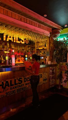 a woman standing in front of a bar at night