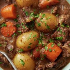 a white bowl filled with stew and potatoes