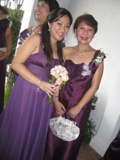 two women in purple dresses standing next to each other