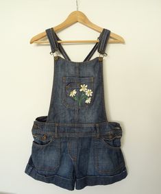 Hand embroidered denim dungarees, second hand item, originally by Pimkie. The flowers were hand-embroidered. Hips: 38 cm Step: 26 cm The design and embroidery was made by hand and they took about 5 hours. The shorts fit like daisy dukes. There are two metal buttons on the side as closure. All items in the shop are second hand, but in very good condition. If you have any doubts about the dimensions or would like more pictures, please send me a message. Upcycled hand embroidered dungarees. Embroidered Dungaree Dress, Senior Jean Jacket, Hand Embroidered Denim, Jean Jacket And Jeans, Long Overalls, Overalls Dress, Cute Overalls, Dungaree Dress, Album Aesthetic