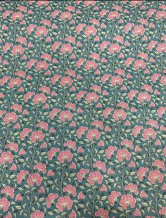 a green and pink floral print fabric with small flowers on the bottom half of it