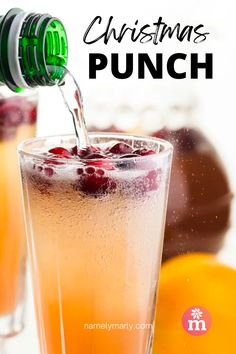 an orange drink being poured into a glass with the words christmas punch in front of it