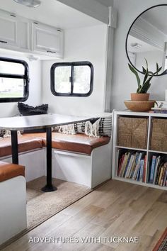 the inside of a camper with two benches and bookshelves on each side