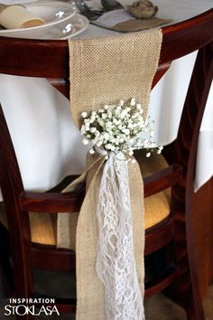 the table is set with white flowers and burlock